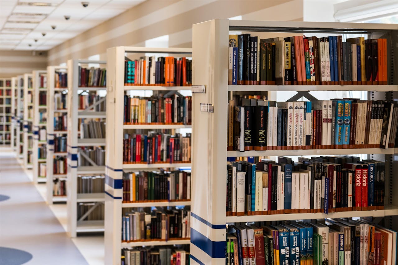 A well-organized library with rows of bookshelves filled with diverse literature.
